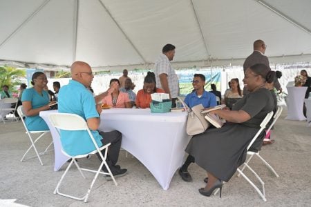 Procurement Specialist Prakash Sookdeo (left) providing information on the procurement process on April 19 at the PPC Open Day. (PPC photo)
