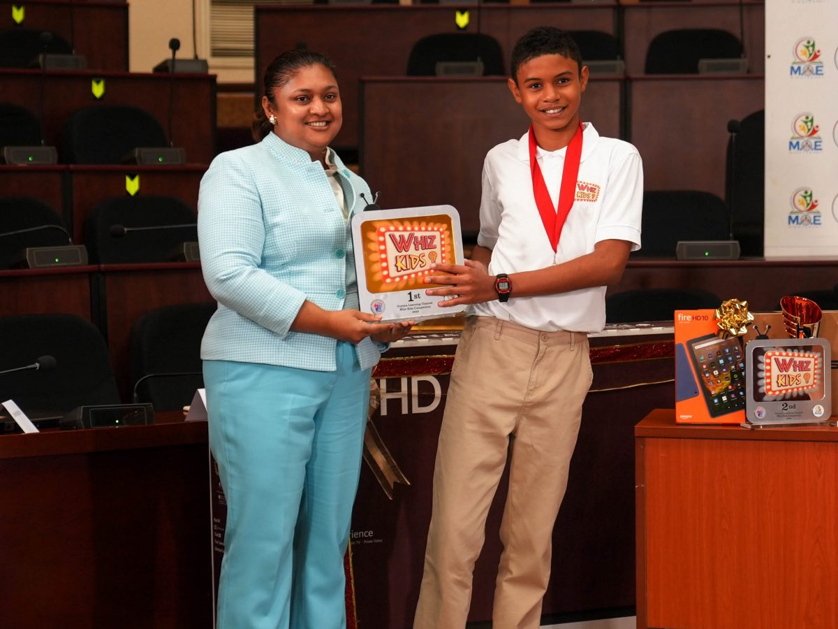 Education Minister Priya Manickchand making a presentation to the top Whiz Kid, Joseph Prendergast (Ministry of Education photo)