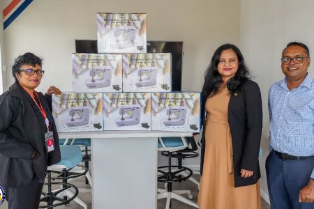 Minister of Human Services and Social Security, Dr. Vindhya Persaud (second from right) along with WIIN coordinator, Sanjay Pooran (right) receives over 100 sewing machines from Silvie’s Industrial Solutions’ Deepawattie Persaud.