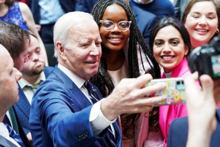 US President Joe Biden takes a selfie with students follwing the 25th anniversary of the Belfast/Good Friday Agreement, at Ulster University, Belfast, Northern Ireland April 12, 2023. Image Credit: REUTERS