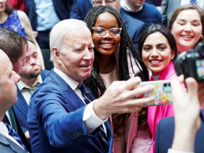 US President Joe Biden takes a selfie with students follwing the 25th anniversary of the Belfast/Good Friday Agreement, at Ulster University, Belfast, Northern Ireland April 12, 2023. Image Credit: REUTERS