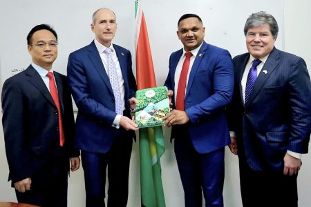 Minister of Natural Resources Vickram Bharrat (second from right) hands over to President of ExxonMobil Guyana, Alistair Routledge, the signed petroleum production licence for Guyana’s fifth offshore development, Uaru. They are joined by Production Manager of CNOOC Guyana  Xu Xiangdong (left) and Hess Corporation's Vice President of Exploration, Appraisal, and Developments for Guyana and Suriname, Tim Chisholm.  (MNR photo)