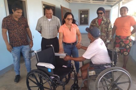 Following a request Minister of Amerindian Affairs Pauline Sukhai, recently presented Moco Moco resident Solomon Lyte with a brand new wheel chair. In this photograph Lyte receives the wheel chair rom Sukhai. (DPI photo)
