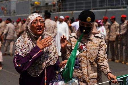 A female Saudi Royal Navy officer assists a women as she disembarks from a Saudi Navy Ship with people from different nationalities evacuated to Saudi Arabia from Sudan, at the Jeddah Sea Port, Saudi Arabia, in this photo released by the Saudi Ministry of Defense on May 8, 2023. (Reuters photo)