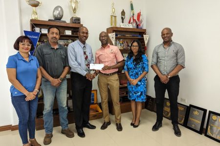  President of the Guyana Olympic Association Godfrey Munroe, Secretary-General, Vidushi Persaud-McKinnon, Treasurer, Garfield Wiltshire who is handing over sponsorship cheque to Ryan Sampson, Honorary Secretary of the Guyana NRA, Dylan Fields, Full-Bore Captain of the Guyana NRA and Emelia Ramdhani, Assistant Secretary of the Guyana Olympic Association. 
