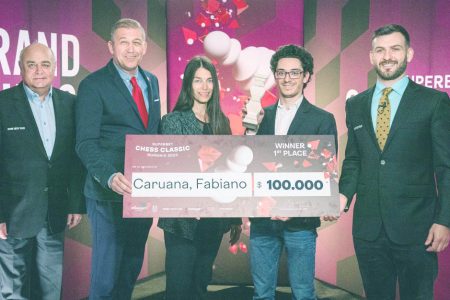 Fabiano Caruana (second, right) with his winner’s cheque of US$100,000 (Photo: Lennart Ootes)
