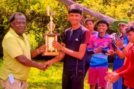 Tournament coordinator James Lewis handing over the championship trophy to the West Demerara Secondary