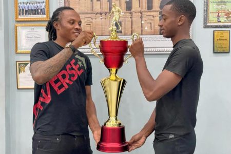Bent Street captain Akel Clarke (left) and Sparta Boss skipper Curtez Kellman displaying the ‘One Guyana’ Futsal Trophy which will be at stake in the final