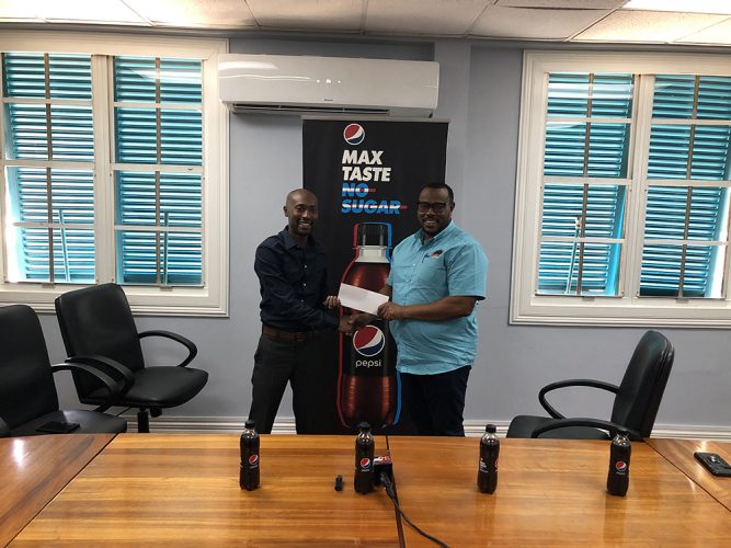 Petra Organization Co-Director Troy Mendonca (right) receiving the sponsorship cheque from Larry Wills, DDL’s Pepsi Brand Manager in support of the ExxonMobil Boys and Girls U14 Football Championship