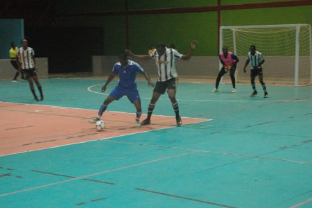 Carl Tudor (right) of North East battling with Rondel Williams of Leopold Street possession of the ball during the ‘One Guyana’ National Futsal Championship at the National Gymnasium, Mandela Avenue