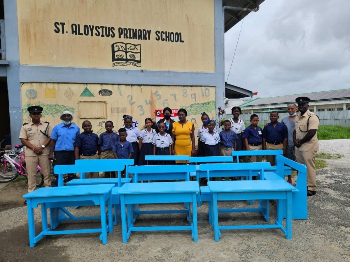 Some of the students and teachers of St Aloysius Primary School along with GPS officials and the donated desks
