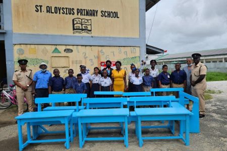 Some of the students and teachers of St Aloysius Primary School along with GPS officials and the donated desks
