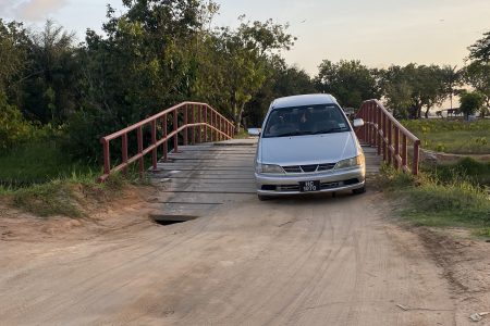  A vehicle crosses the bridge with the hole evident 