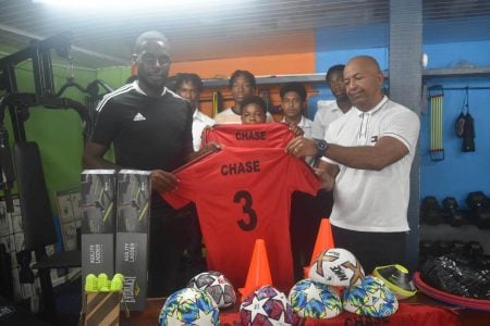 Jeremy Garrett presents the football equipment to Chase’s Academy principal Henry Chase.