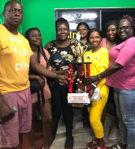 Tournament coordinator Roderick Harry (left) presents the first place package to the victorious C-Point unit who were crowned  champions of the ‘Tribute to Mothers’ Domino Championship