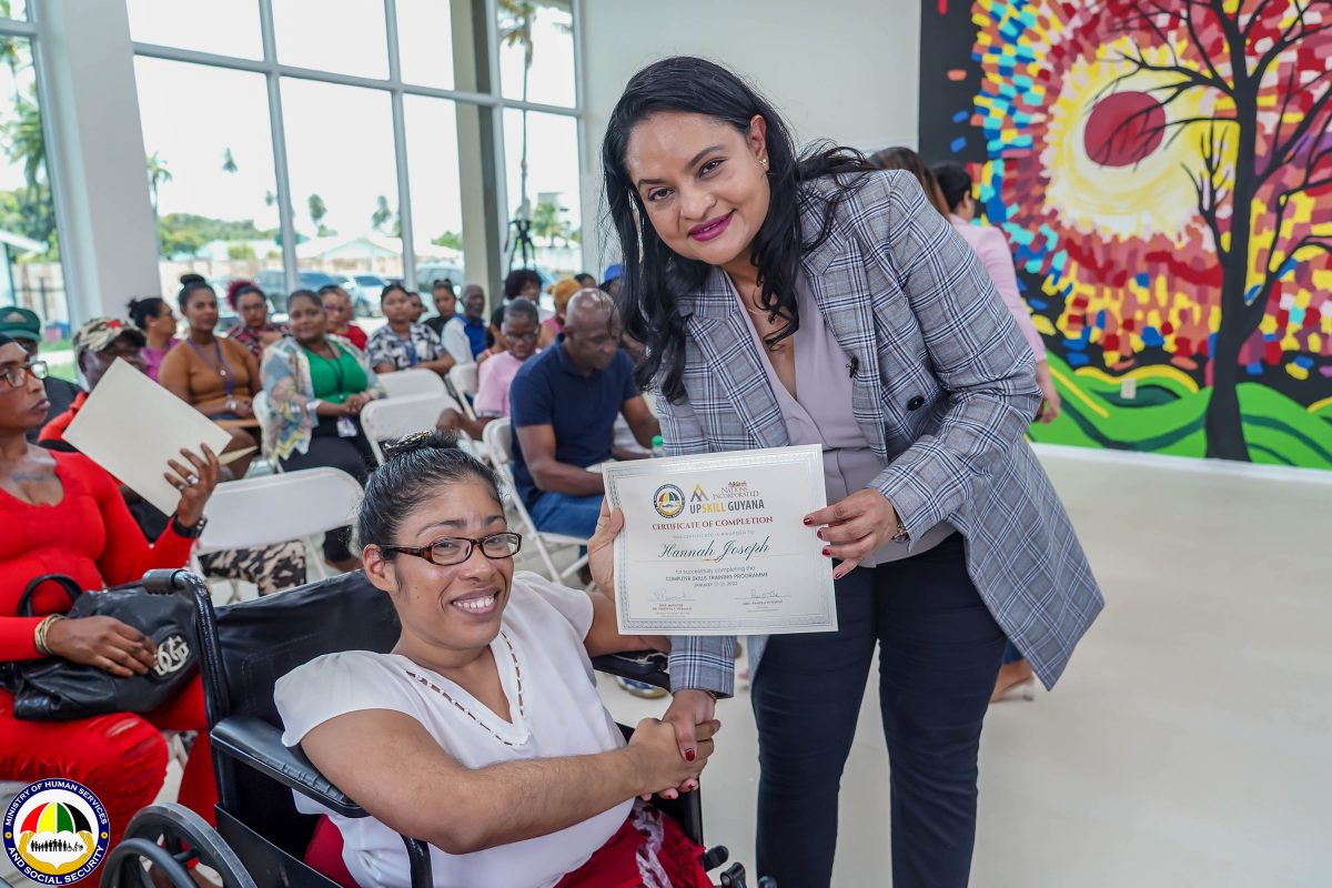 Minister of Human Services and Social Security, Dr Vindhya Persaud (right) hands over to Hannah Joseph her certificate