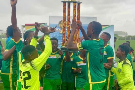 East Coast Demerara celebrates their Tiger Rentals League Cup triumph in the rain following their final’s win over Bartica at the National Training Centre, Providence yesterday.