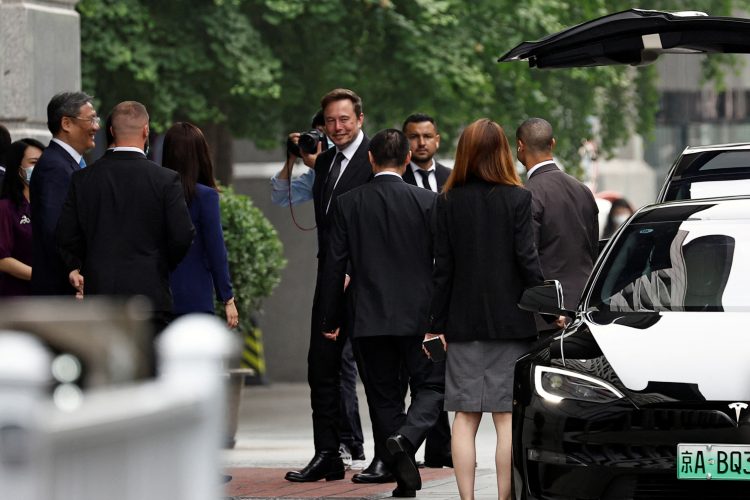 Tesla Chief Executive Officer Elon Musk stands near Chinese Commerce Minister Wang Wentao before leaving the Chinese Ministry of Commerce in Beijing, China May 31, 2023. REUTERS/Tingshu Wang