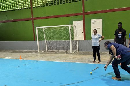 Vice-President of G.O.A., Philip Fernandes in his first attempt at bocce at the National Gymnasium in the presence of members of the Special Olympics Guyana Team.