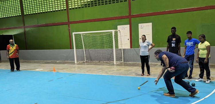 Vice-President of G.O.A., Philip Fernandes in his first attempt at bocce at the National Gymnasium in the presence of members of the Special Olympics Guyana Team.