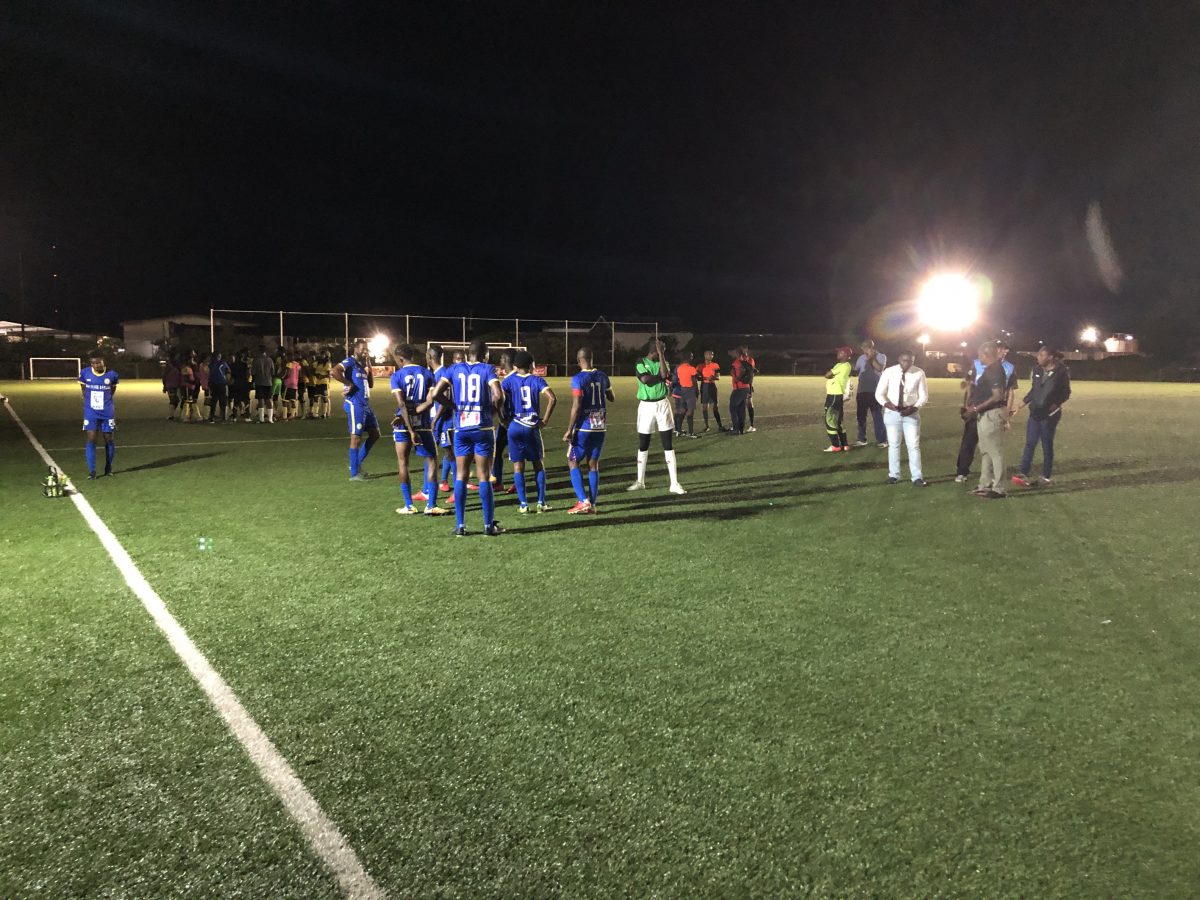 Players from Western Tigers (yellow) and Victoria Kings (blue) as well as referees and GFF officials deliberating on the field minutes before the abandonment of the KFC Elite League fixture