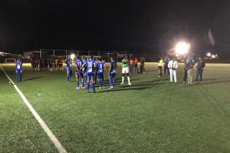 Players from Western Tigers (yellow) and Victoria Kings (blue) as well as referees and GFF officials deliberating on the field minutes before the abandonment of the KFC Elite League fixture