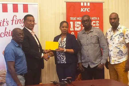 Co-Director of the Kashif and Shanghai Organization Kashif Muhammad, second left, receives the sponsorship cheque from KFC Guyana Marketing Manager Pamela Manasseh. Also in the photo are Kashif and Shanghai Co-Director Aubrey Major (2nd from right), Colin `BL’ Aaron (1st from left) and Frank `Engliash’ Parris