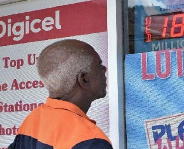 A Lotto player looks at the signage at a National Lotteries Control Board outlet on Pointe-a-Pierre Road, San Fernando, on Wednesday, advertising the Lotto Plus jackpot of $18.5 million.