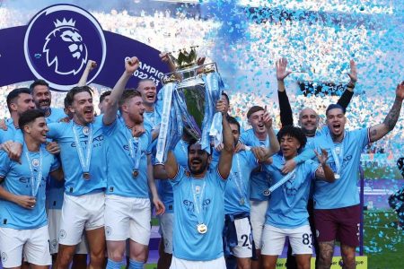 Manchester City’s Ilkay Gundogan lifts the trophy as he celebrates with teammates after winning the Premier League. Images via Reuters/Lee Smith