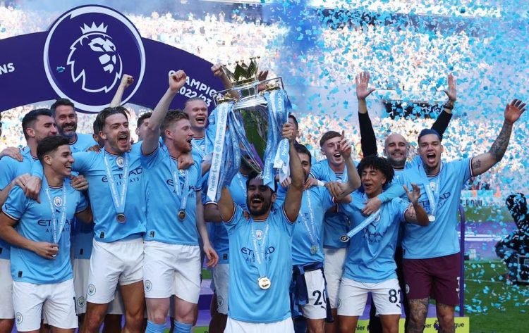 Manchester City’s Ilkay Gundogan lifts the trophy as he celebrates with teammates after winning the Premier League. Images via Reuters/Lee Smith