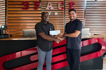 Manager of Space Gym 2.0, Lucas Matos (right) presents the sponsorship cheque to GAPLF President, Franklin Wilson.