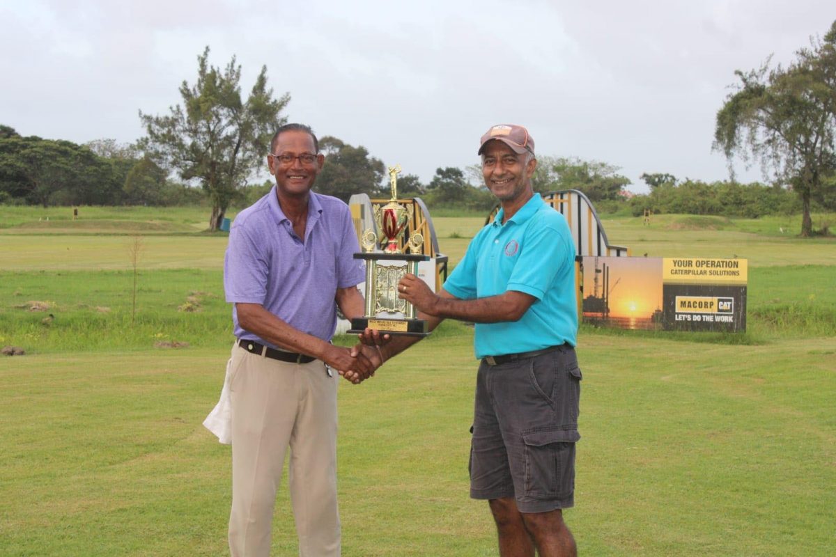 Patrick Prashad (left) receives his prize for winning the Massy Motors golf tournament from Massy Motors CEO, Mahesh Shivraj.