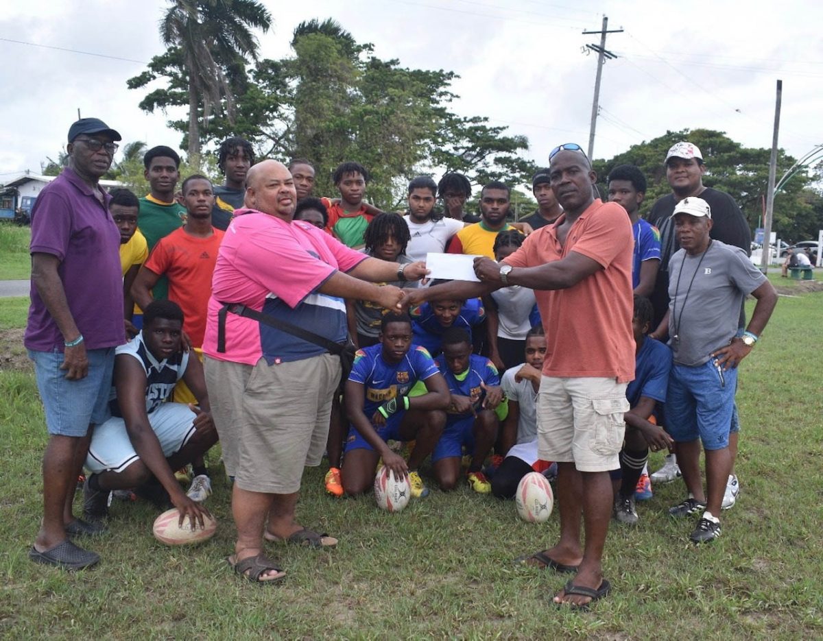 Troy Yhip (center left) receives the
sponsorship cheque from Franklyn Victor.