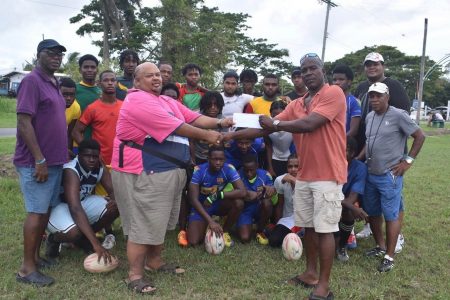 Troy Yhip (center left) receives the
sponsorship cheque from Franklyn Victor.