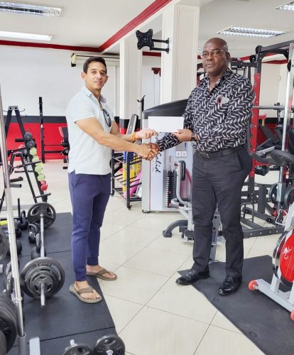 CEO of Fitness Express, Jamie McDonald, hands over the sponsorship package to GAPLF President, Franklin Wilson.