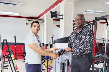 CEO of Fitness Express, Jamie McDonald, hands over the sponsorship package to GAPLF President, Franklin Wilson.