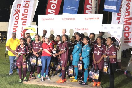 Waramuri skipper receives the female team’s championship trophy after they defeated President’s College in the final of the ExxonMobil U14 Football Championships.