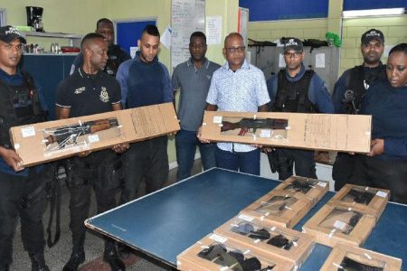 ‘Fighting a hard battle’: Senior Superintendent Richard Smith, fourth from right, and officers of the Southern Division Task Force display four AR-15 rifles and 11 magazines at the Marabella Police Station yesterday. The items were seized from a Venezuelan national on Friday night on the M2 Ring Road, close to Debe. 