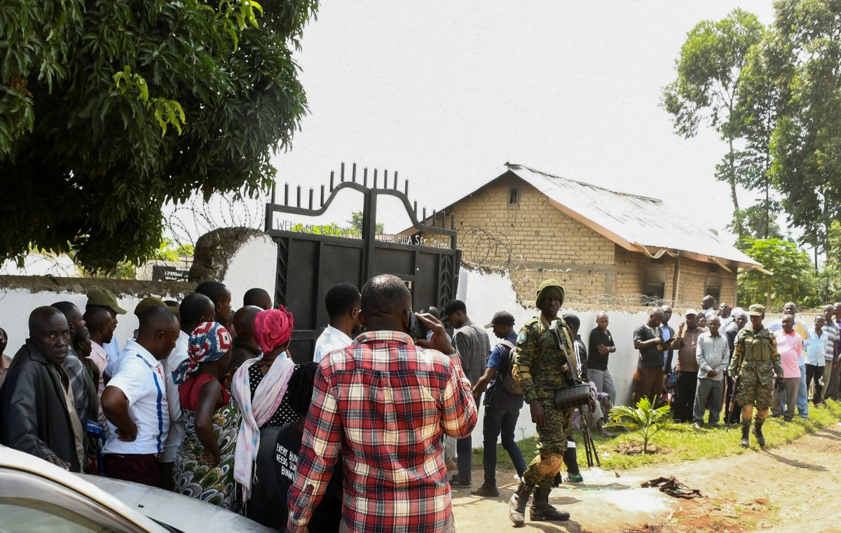 Ugandan security forces stand guard as locals gather at the cordoned scene outside the Mpondwe Lhubirira Secondary School, after militants linked to rebel group Allied Democratic Forces (ADF) killed and abducted multiple people, in Mpondwe, western Uganda, June 17, 2023. REUTERS/Stringer