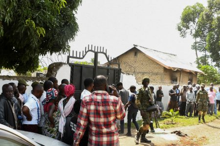 Ugandan security forces stand guard as locals gather at the cordoned scene outside the Mpondwe Lhubirira Secondary School, after militants linked to rebel group Allied Democratic Forces (ADF) killed and abducted multiple people, in Mpondwe, western Uganda, June 17, 2023. REUTERS/Stringer