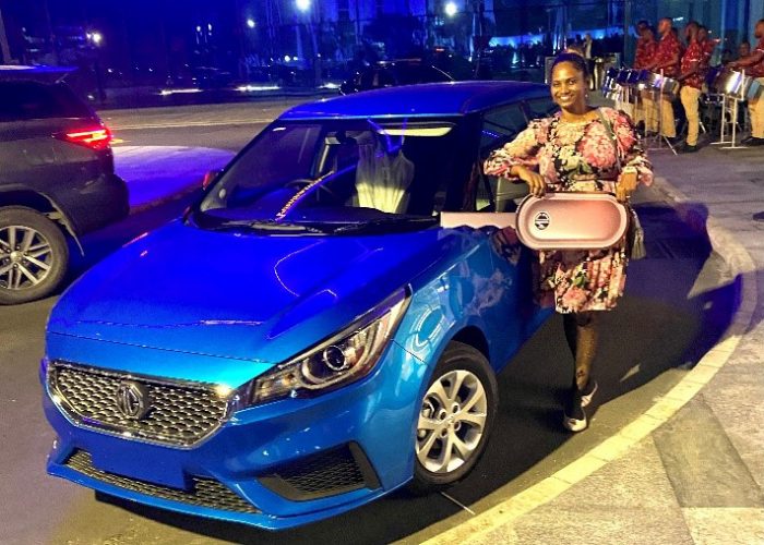 Janette Worrell poses next to her brand new MG 3 which she won in a raffle from Massy Motors.