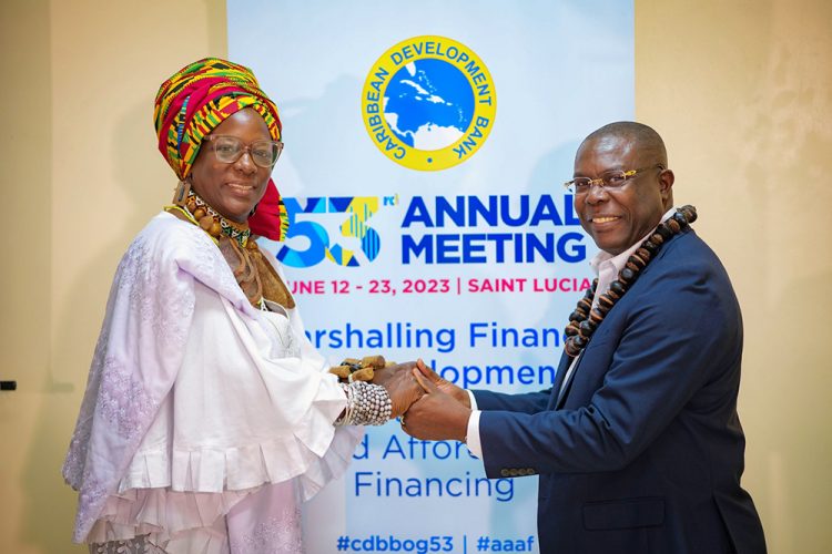 Isaac Solomon, (right) Vice President, Operations, Caribbean Development Bank (CDB) exchanges greetings with Akilah Jaramogi, Merikin Chief and Yaruba Spiritual Leader from Trinidad and Tobago at the Indigenous Peoples’ Forum. (CDB photo) 