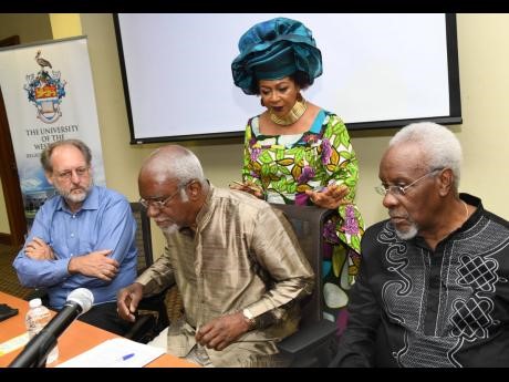 Professor Verene Shepherd (standing second from right) looks on as Dr Coleman Bazelon (left), practice co-leader: intellectual property, Brattle Group; Judge Patrick Robinson (centre), former honorary president of the American Society of International Law and P.J. Patterson, former prime minister of Jamaica and statesman in residence of P.J. Patterson Institute for Africa-Caribbean Advocacy of The UWI, at the launch of the report on the quantification of reparation for transatlantic chattel enslavement in the Americas and Caribbean. The event was hosted at the University of the West Indies, regional headquarters in Kingston yesterday.