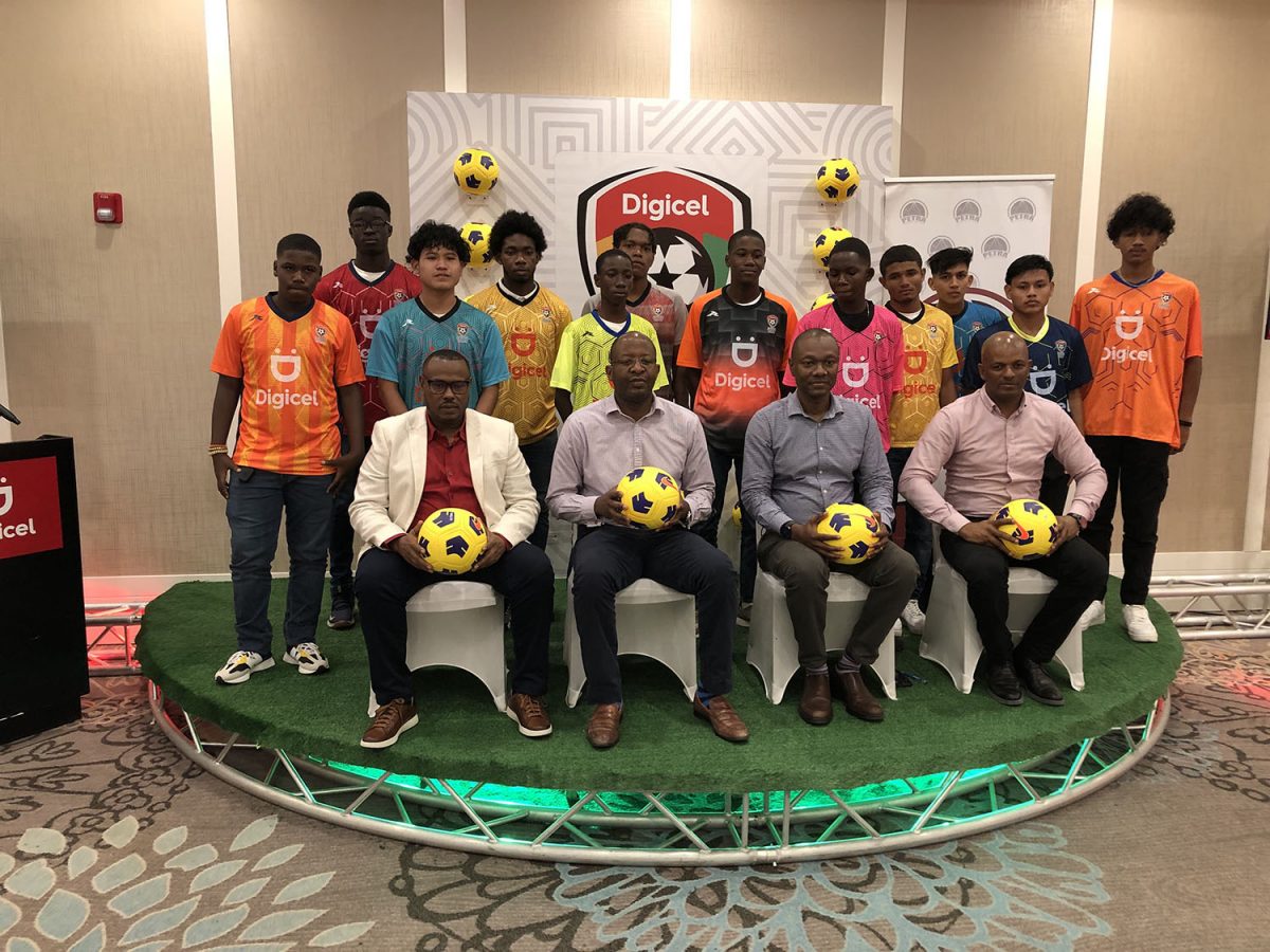 Members of the Digicel Schools Football Championship launch party [sitting left to right] Petra Co-Director Troy Mendonca, Digicel CEO Gregory Dean, GFF Executive Committee Member Dion Inniss, and Guyana Olympic Association President Godfrey Munroe posing with the representatives of the several schools 
