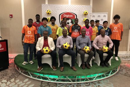 Members of the Digicel Schools Football Championship launch party [sitting left to right] Petra Co-Director Troy Mendonca, Digicel CEO Gregory Dean, GFF Executive Committee Member Dion Inniss, and Guyana Olympic Association President Godfrey Munroe posing with the representatives of the several schools 