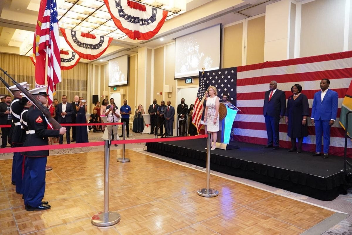 US Ambassador Sarah-Ann Lynch at front of podium during the presentation of colours by the US marines.