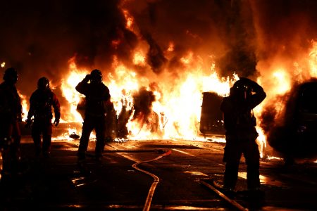 Firefighters stand as they extinguish burning vehicles during clashes between protesters and police, after the death of Nahel, a 17-year-old teenager killed by a French police officer during a traffic stop, in Nanterre, Paris suburb, France, June 28, 2023. REUTERS/Stephanie Lecocq