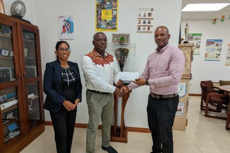 President of the Guyana Olympic Association Godfrey Munroe (right) handed over the sponsorship cheque to President of the Guyana Amateur Powerlifting Federation, Franklin Wilson in the presence of Secretary-General of the Association, Vidushi Persaud-McKinnon. 
