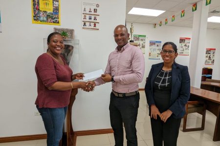 Secretary of the Guyana Rugby Football Union, Petal Adams received the sponsorship cheque from President of the Guyana Olympic Association, Godfrey Monroe in the presence of Secretary-General of the Association, Vidushi Persaud-McKinnon (on right).