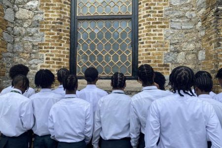 LEFT OUT: Some of the graduating pupils of Trinity College, Moka, who weren’t allowed to take part in their graduation ceremony, gather outside All Saints Anglican Church, Port of Spain, during the function on Tuesday.